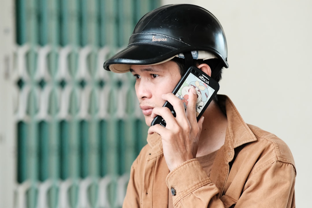 a man wearing a helmet talking on a cell phone