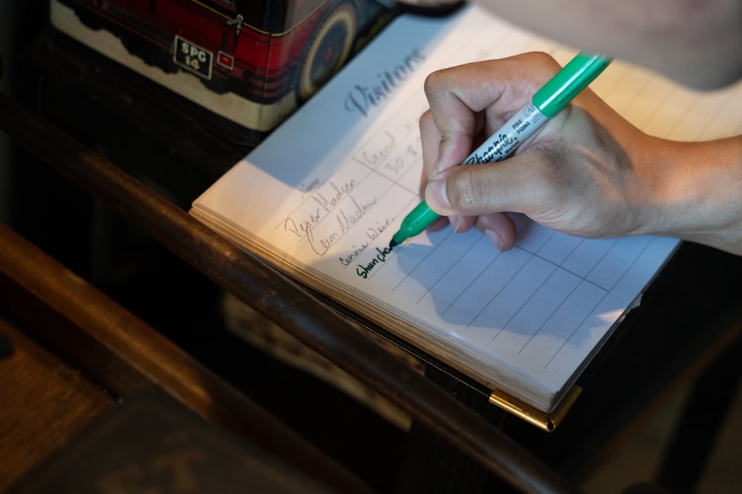 Someone is signing a visitors' logbook.