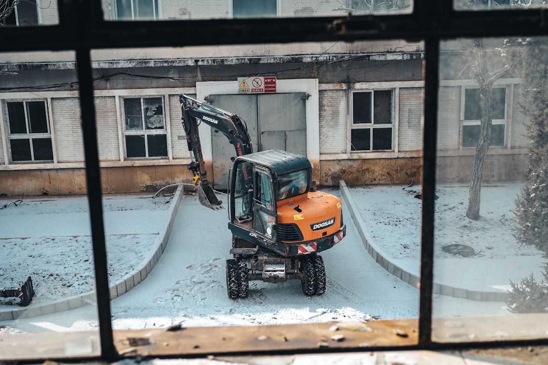 Orange excavator parked outside a building
