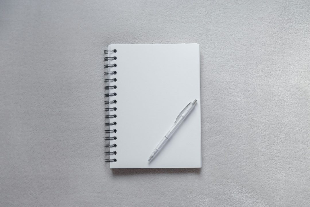 予定を書き込む白いノートとペン