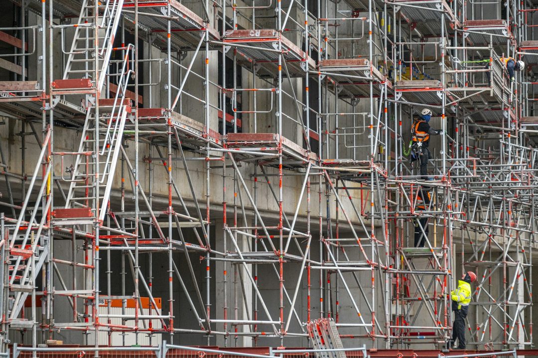 足場が組まれた建設中の建物と作業員
