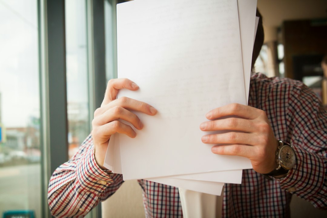 書類を見ながら頭を抱える作業着の男性